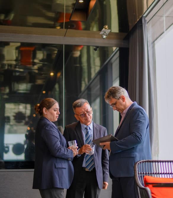 Professional business professionals discussing data on tablet in modern office.
