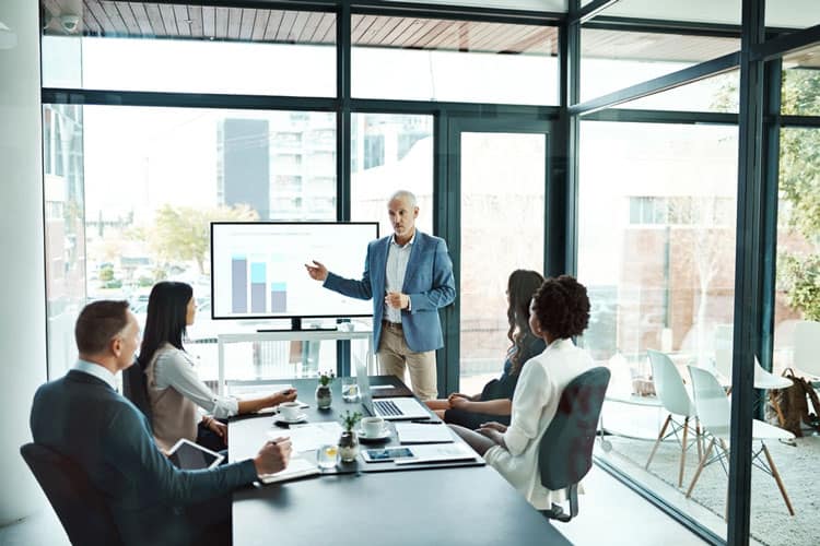 Efficient business meeting in modern conference room with presentation and analytics.
